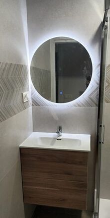 mueble y espejo con luz en el baño